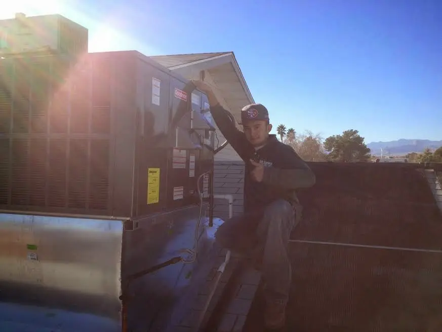 HVAC technician performing AC Tune-Up on a rooftop unit in Lancaster